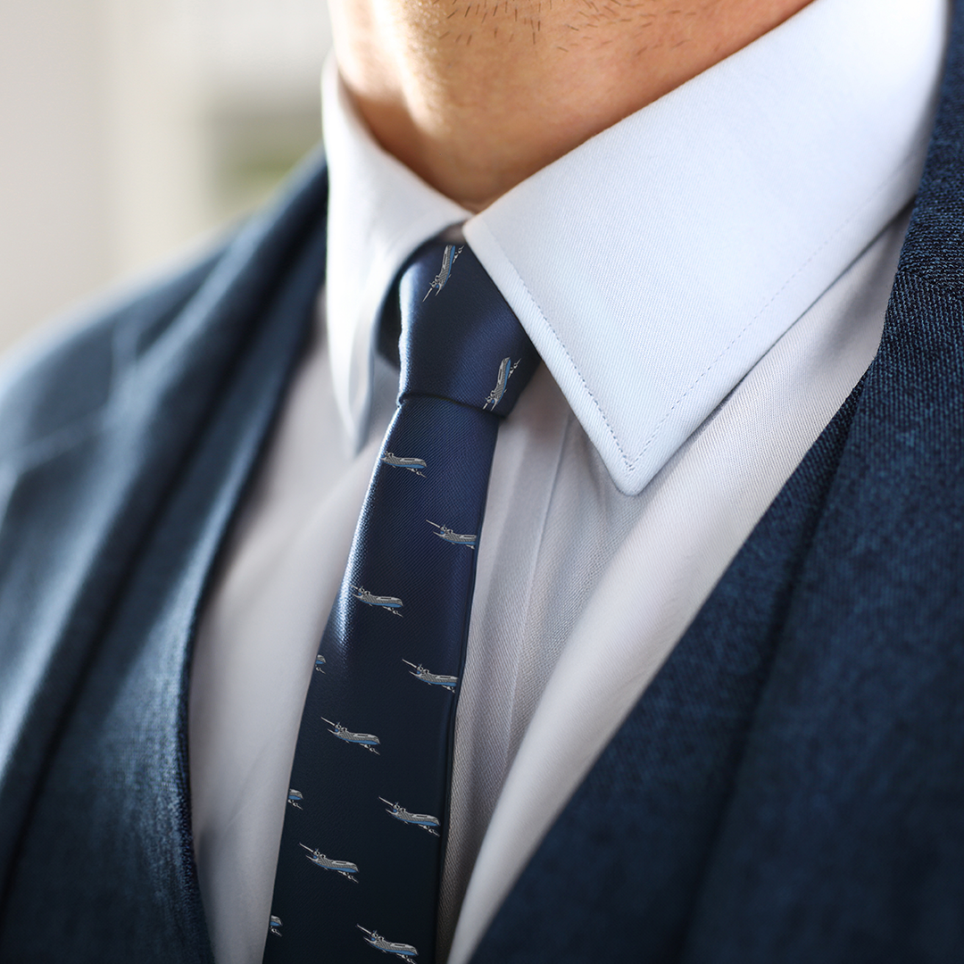Close-up of a person wearing a blue suit jacket, white dress shirt, and an Aeroplane Thin Tie, exuding aeronautical charm.