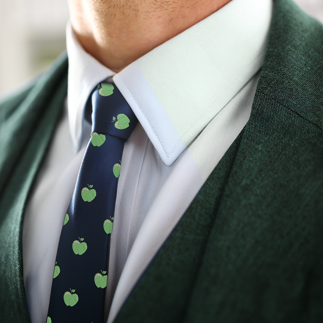 Close-up of a person wearing a green suit jacket, a white shirt, and an Apple Thin Tie, showcasing modern style and natural freshness.
