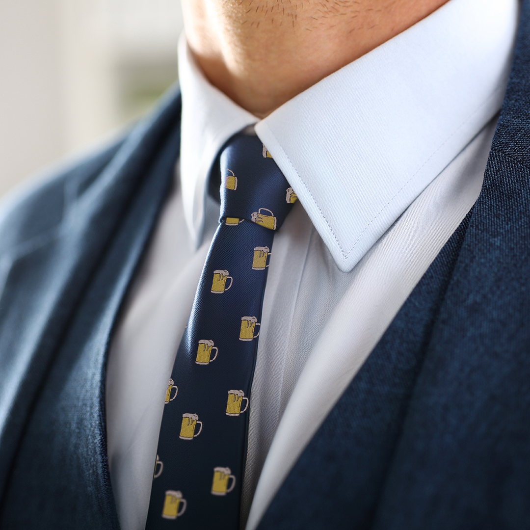 Close-up of a person in a blue suit, white shirt, and a Beer Slim Tie, exuding both modern style and conviviality.