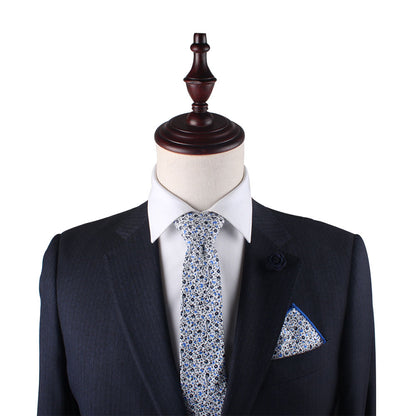 A mannequin displaying a Black Light Blue Floral Cotton Skinny Tie & Pocket Square Set against a midnight backdrop.