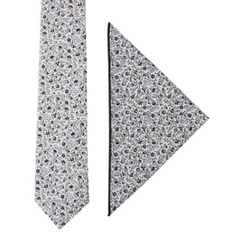 A sleek design featuring the Black Print Floral Cotton Skinny Tie & Pocket Square Set is laid out on a plain white background. The pattern consists of subtle florals in blue, white, and black.
