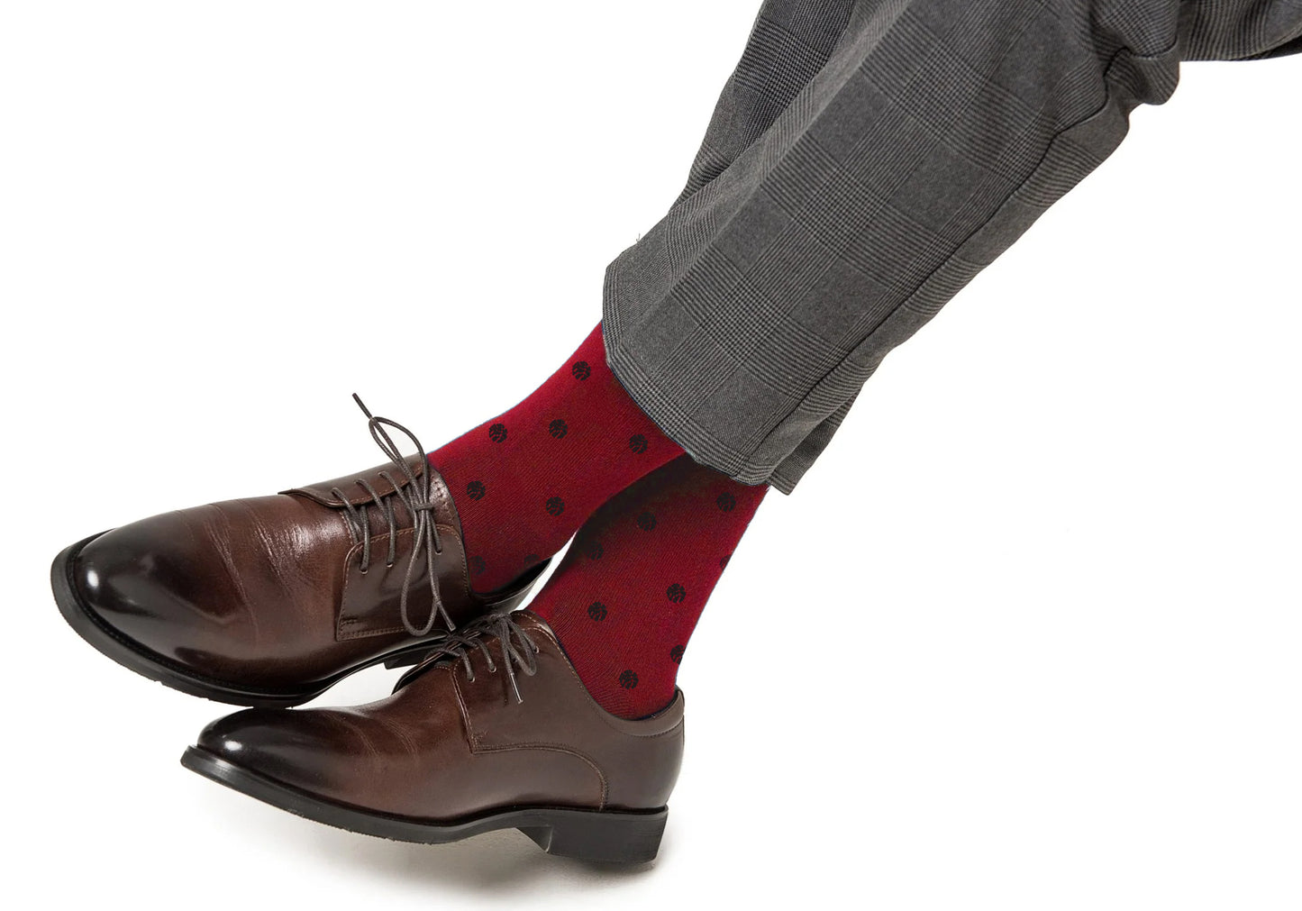 A person wearing gray plaid pants, blue basketball socks for cushioned support, and brown leather dress shoes.