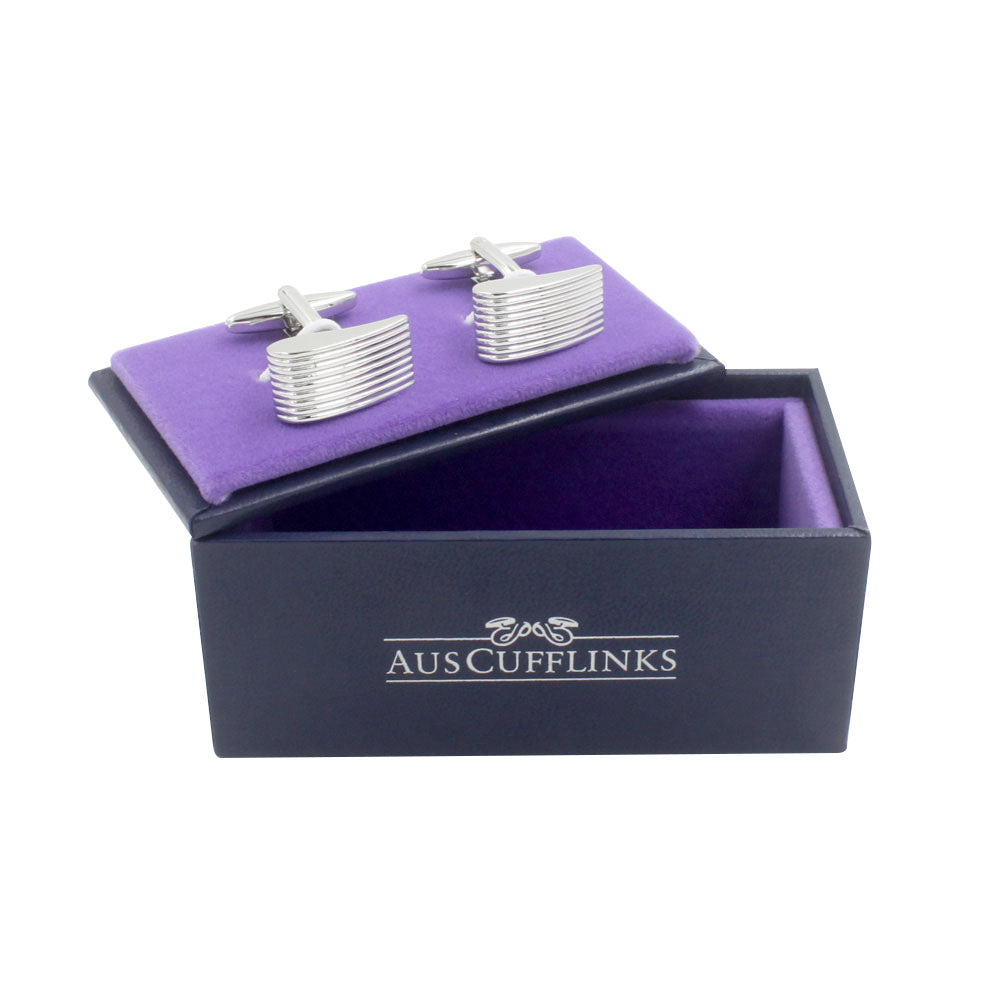 Horizontal Sweep Cufflinks featuring a ribbed design and linear elegance are displayed on a purple velvet cushion inside an open dark blue box labeled "AUSCUFFLINKS.