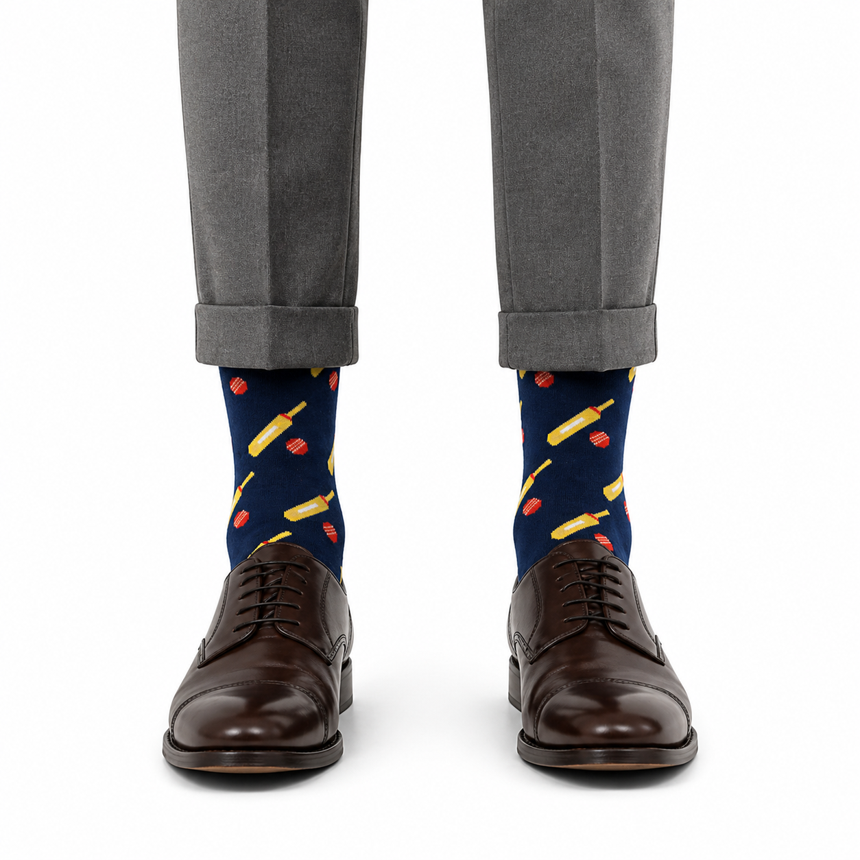 A person wearing gray dress pants, dark brown Oxford shoes, and navy Cricket Bat & Ball Socks.