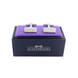 A pair of Cylinder Cufflinks in a purple box, polished finish.