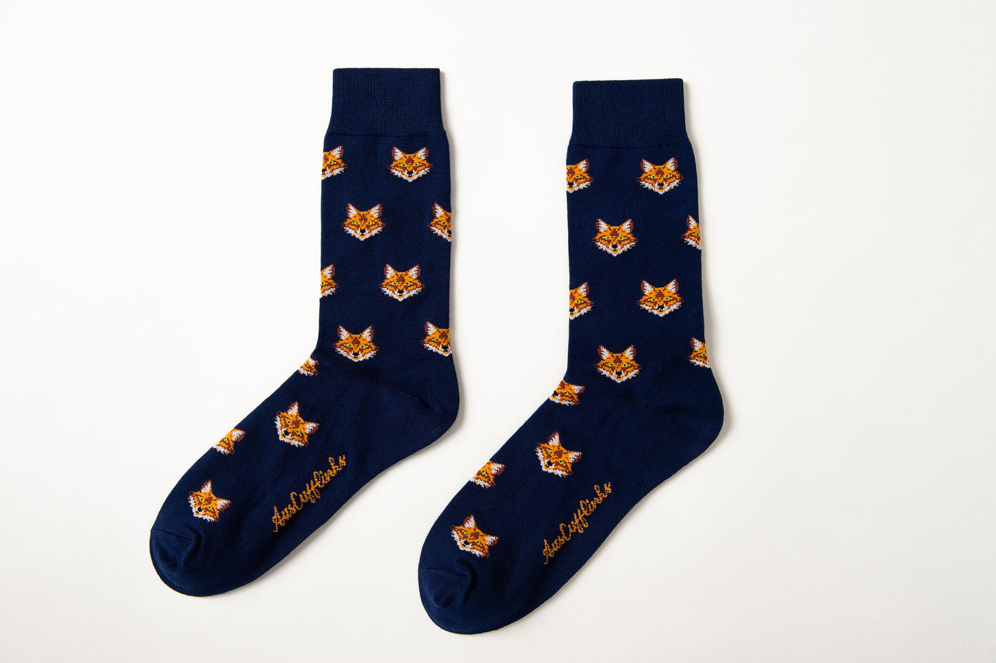 Fox Head Socks: A pair of navy blue novelty socks with a repeating fox face design and yellow script near the toes, shown on a white background.