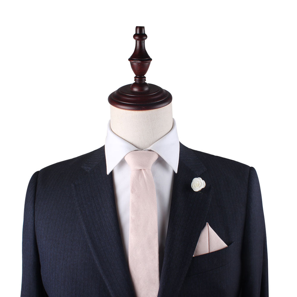 A mannequin dressed in a dark suit with a white dress shirt, Light Pink Cotton Business Tie & Pocket Square Set, and a white flower lapel pin exudes timeless sophistication. The refined ensemble is perfect for any occasion that demands elegance.