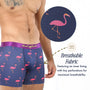 A man wears Pink Flamingo Underwear—navy boxer briefs with a purple waistband and playful print; a close-up reveals fabric perforations, showing these tropical boxers are breathable and moisture-wicking.