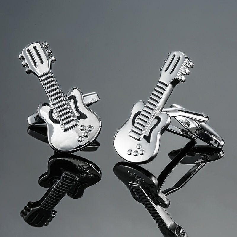 The Electric Guitar Cufflinks, with their chic silver design, rest elegantly on a reflective gray surface, capturing the rhythm of strumming chords.