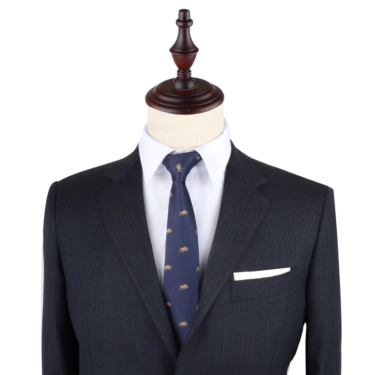 A tailored dark suit with a white pocket square and the Raging Bull Skinny Tie in navy featuring a subtle bull motif, displayed on a mannequin with a wooden top.