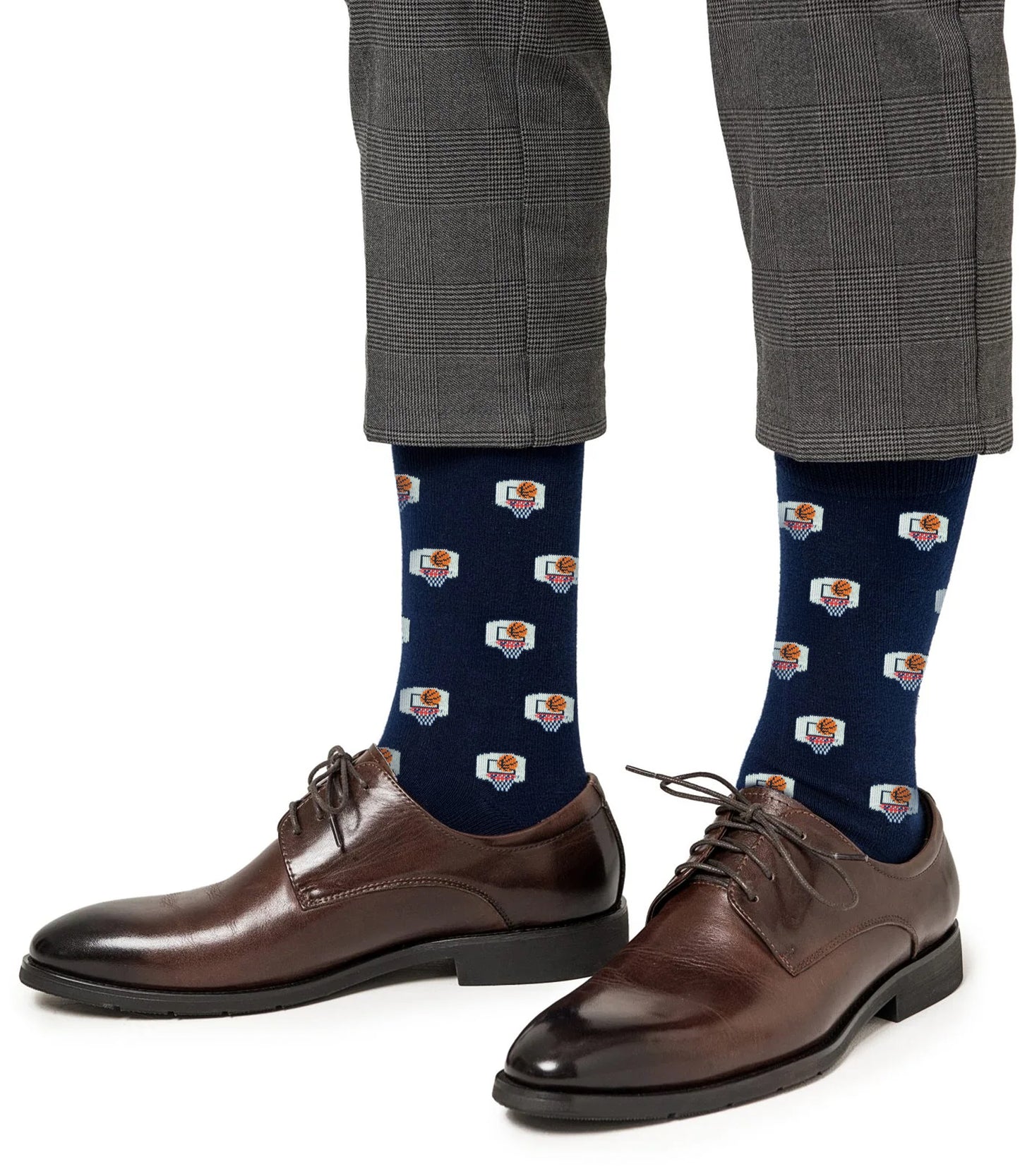 Man wearing gray plaid pants, brown dress shoes, and Basketball Backboard Socks—blue performance athletic socks featuring a repeating computer and rose graphic pattern.