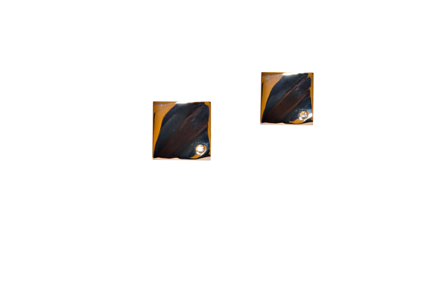 Displayed against a white background are two square brown objects with dark markings and a small circular detail, resembling the luxury of Silver Stone Cufflinks.