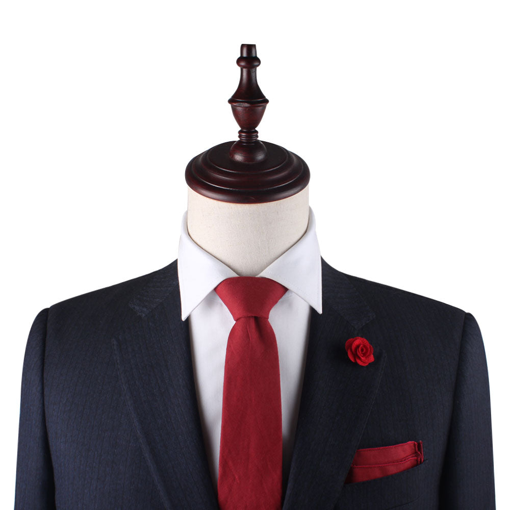 The mannequin in a dark suit exudes power and style with its white shirt, accented by the Red Cotton Business Tie & Pocket Square Set. A red rose lapel pin adds passion against the pristine white background.