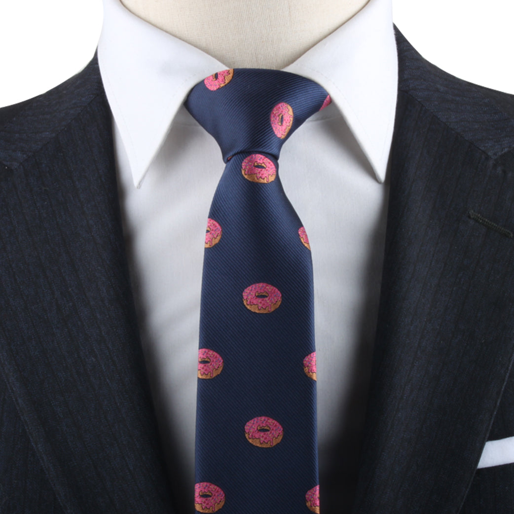 Navy tie with Donut Skinny Tie pattern on a mannequin wearing a white shirt and dark suit jacket, adding delectable style.