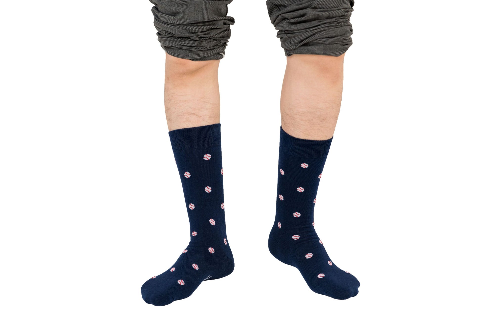 A person's legs adorned with baseball socks.