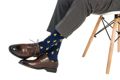 A man sitting on a chair wearing a pair of Duck Socks.