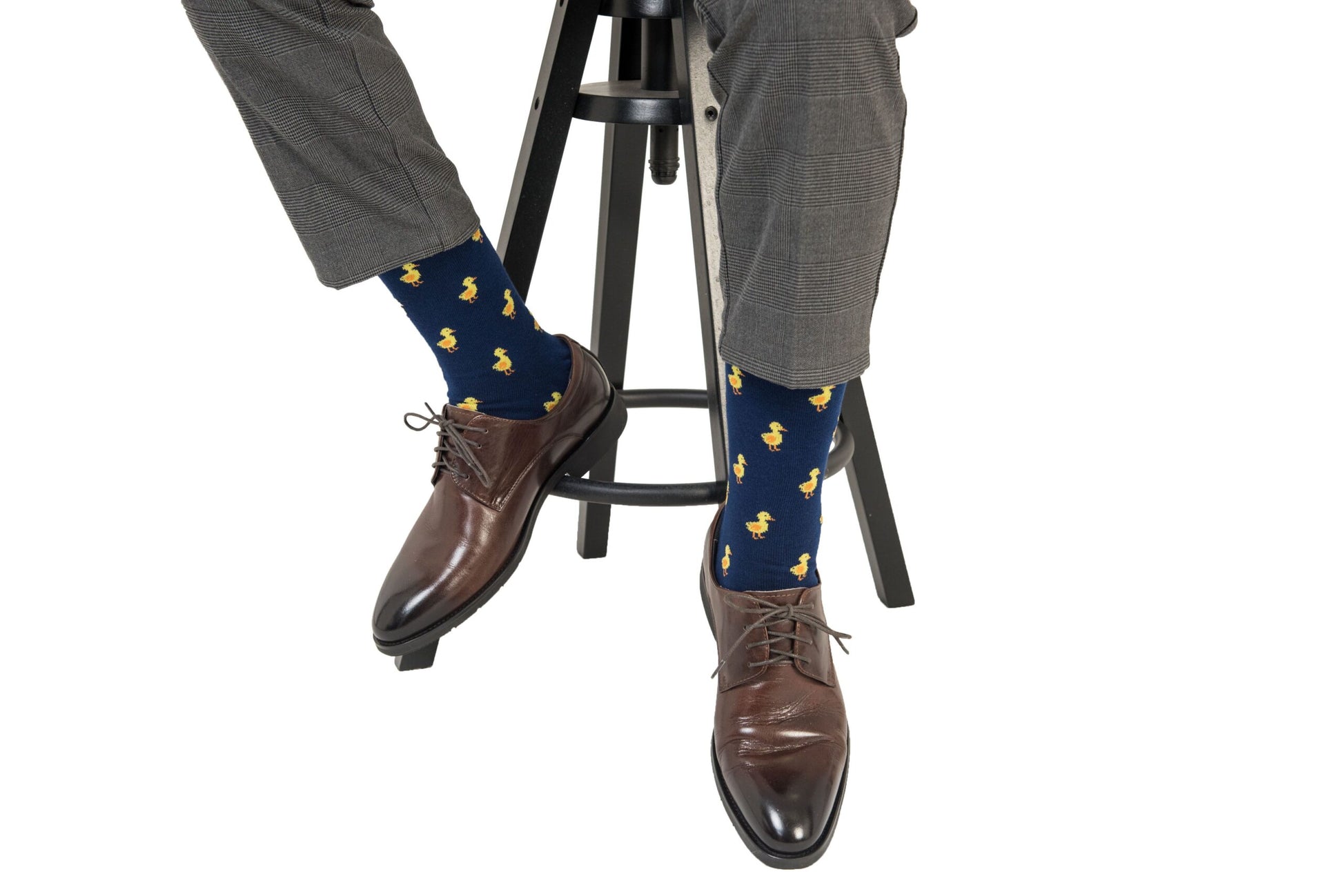 A man sitting on a stool wearing a pair of Duck Socks.