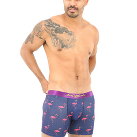 A bald man with a chest tattoo stands confidently in Pink Flamingo Underwear, isolated on a white background.
