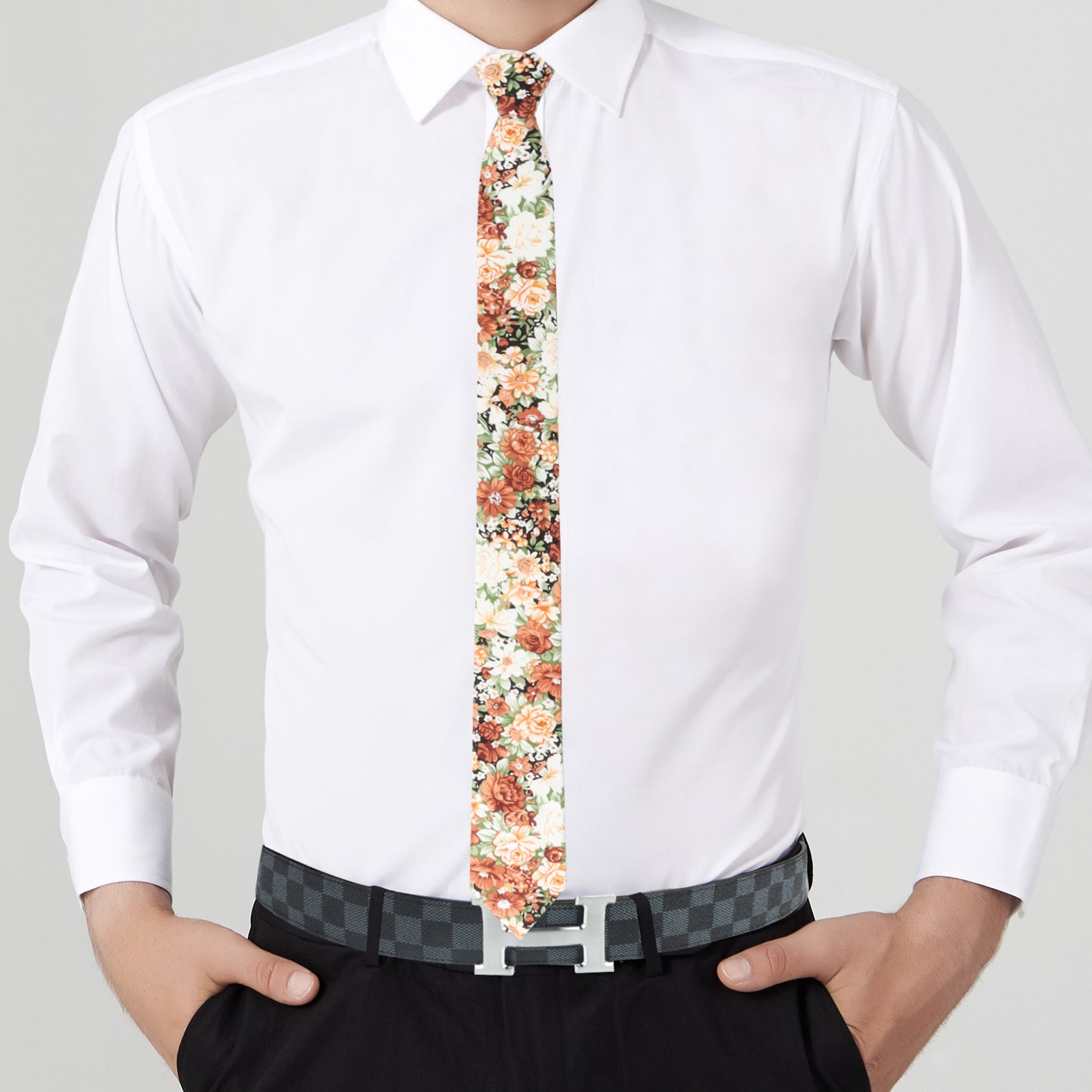 Person wearing a white dress shirt and a **Floral Artisan Skinny Tie**, with hands in pockets of black trousers and a checkered belt—a true embodiment of nature’s masterpiece in dapper design.