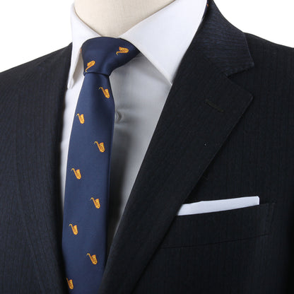 Saxophone Skinny Tie adorned with musical elegance through yellow patterns, displayed on a mannequin donning a redefined dark blazer and a white pocket square.