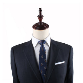 Navy blue suit jacket on a mannequin with a Watch Skinny Tie, white pocket square, and a wooden neck stand against a white background, epitomizing timeless elegance.