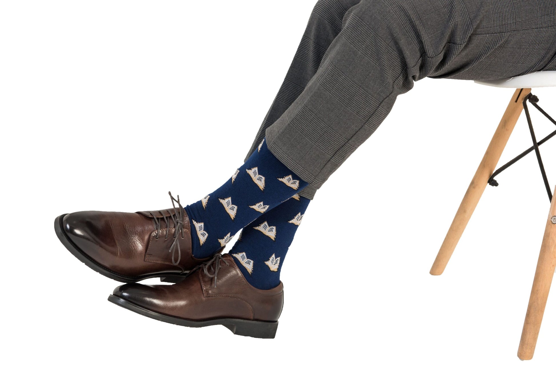 A man sitting on a chair wearing a pair of Book Socks.