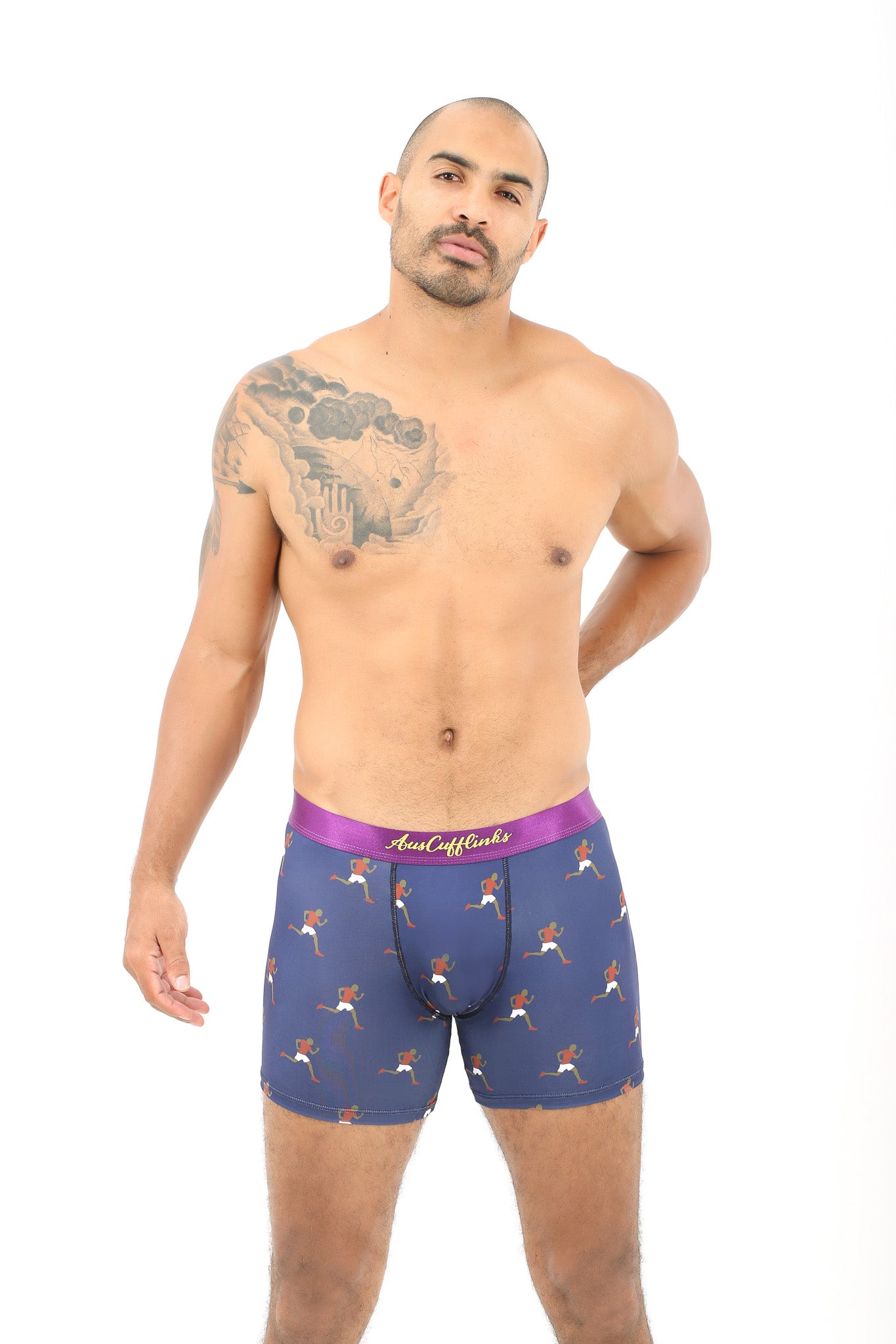 A man with a tattoo on his shoulder, radiating comfort in Athletics Underwear, stands against a white background.