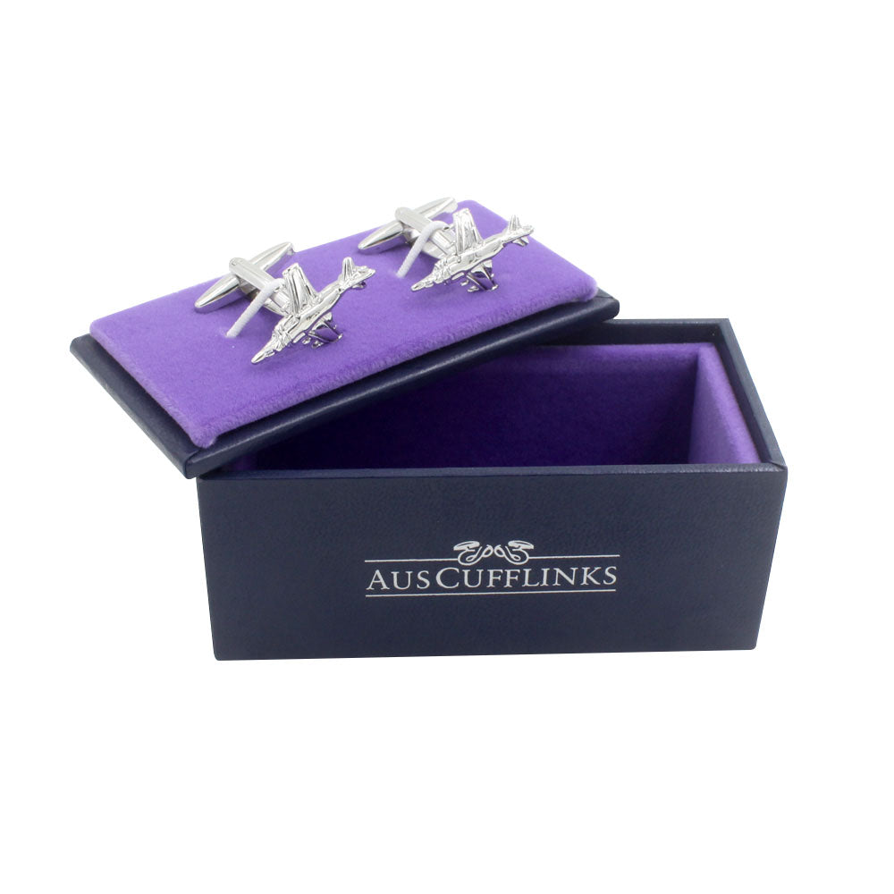 These aviation-themed Fighter Jet Cufflinks, displayed on a purple fabric lining inside an "AusCufflinks" black box, feature a sleek silver design, making them a unique gift for aviation enthusiasts.