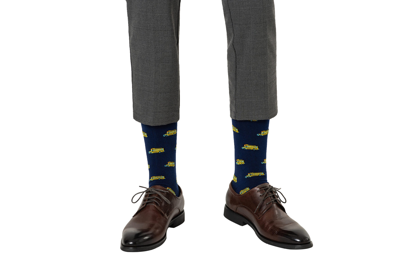 Man wearing brown dress shoes and gray pants, taking a step to reveal School Bus Socks, evoking a sense of nostalgia.