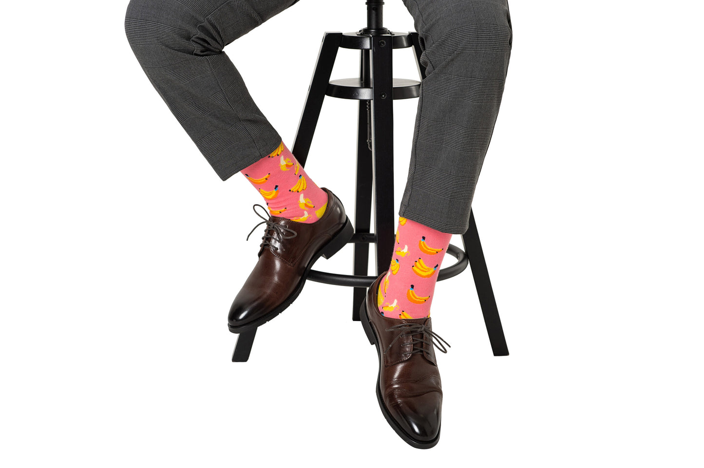 A man sitting on a stool wearing Banana Pink Socks.