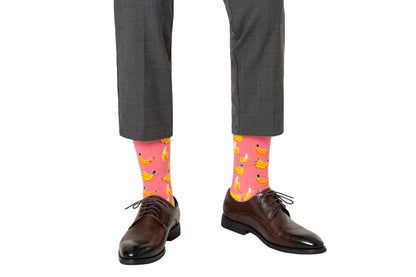 A pair of legs with Banana Pink Socks on them.