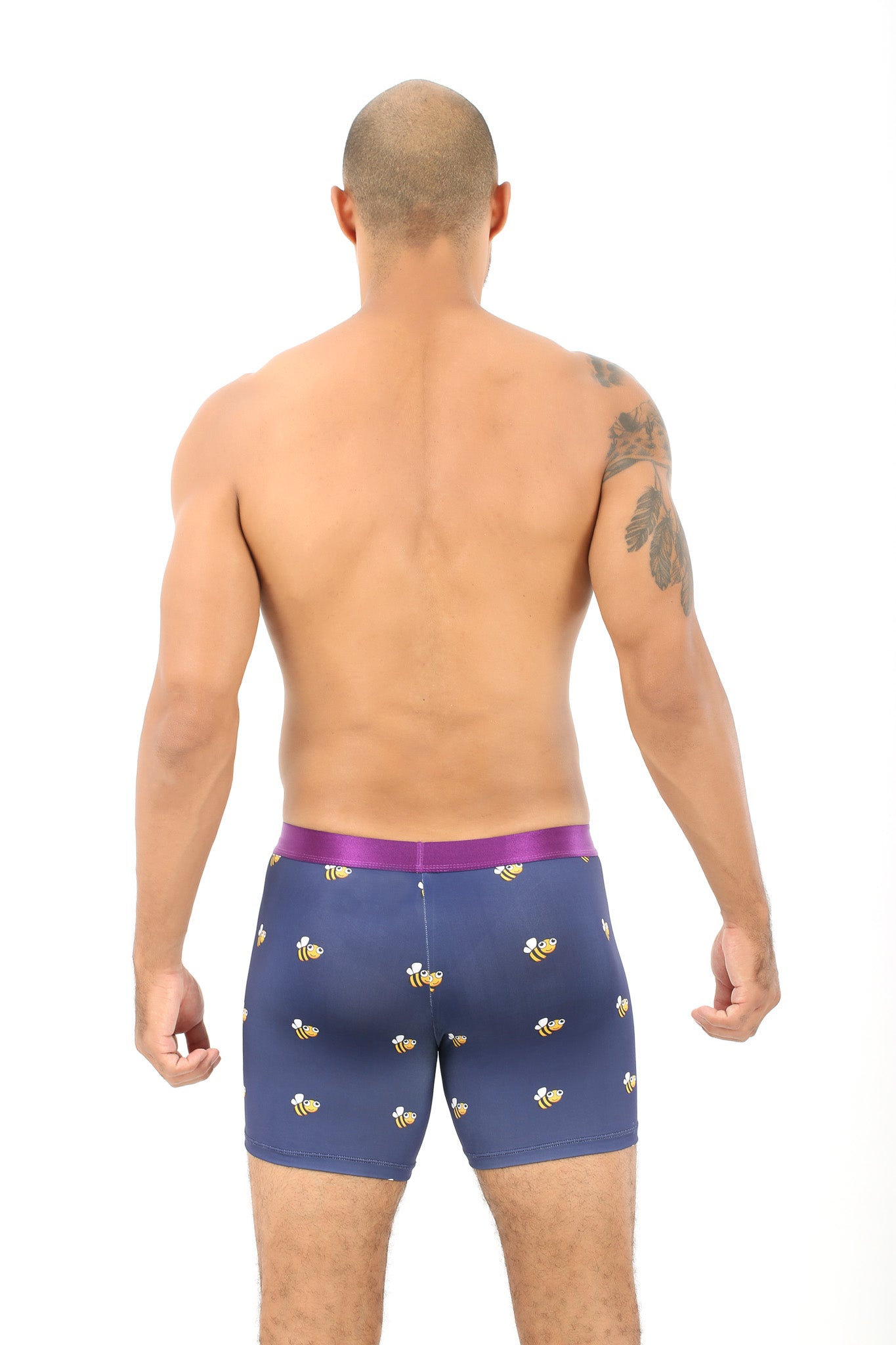 A shirtless person stands facing away, wearing Bee Underwear for Men – Gift for Beekeepers, featuring a playful bee pattern and a purple waistband.