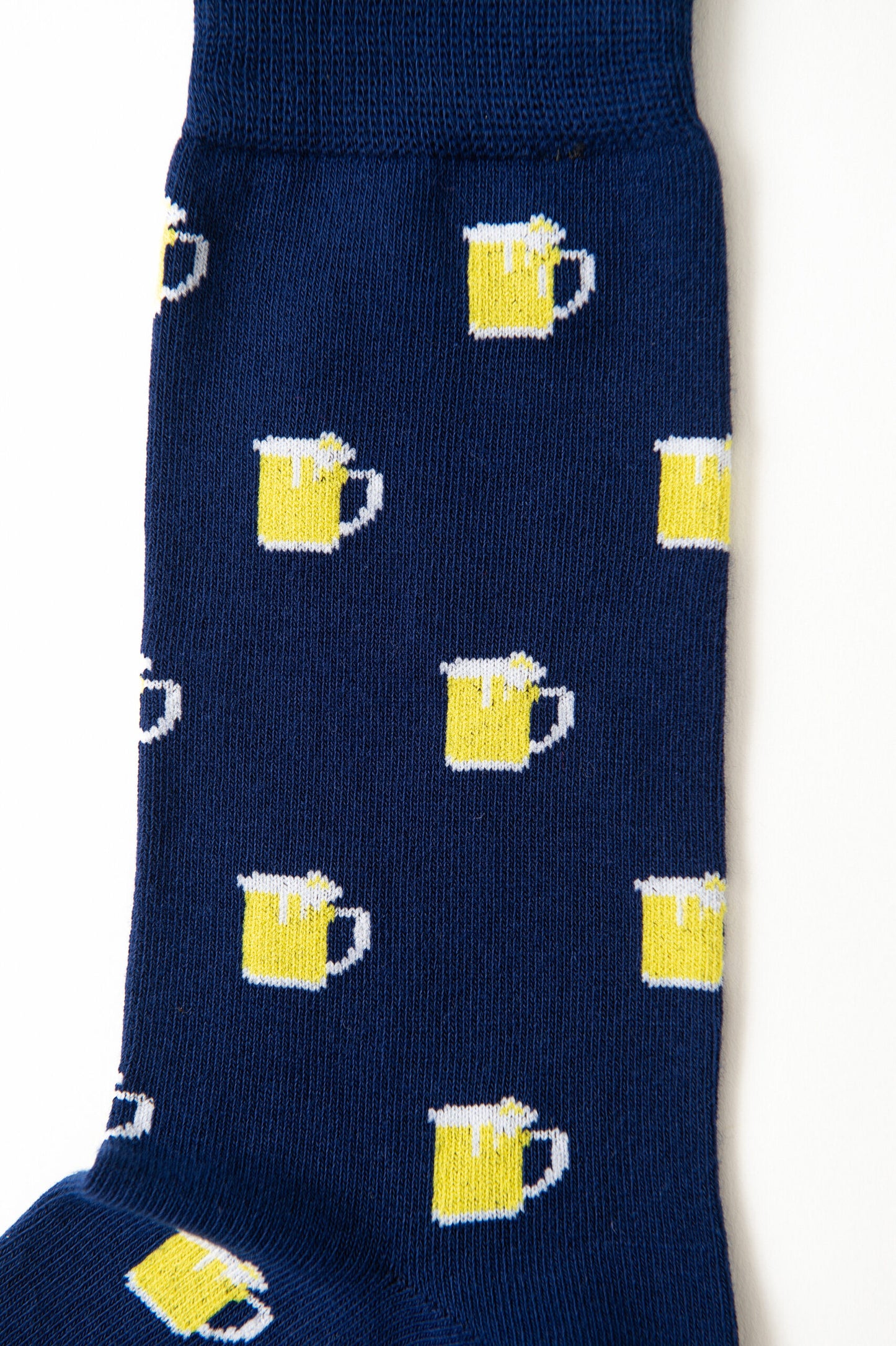 Beer Socks are navy blue with a playful pattern of yellow beer mugs topped with white foam, perfect for beer lovers.