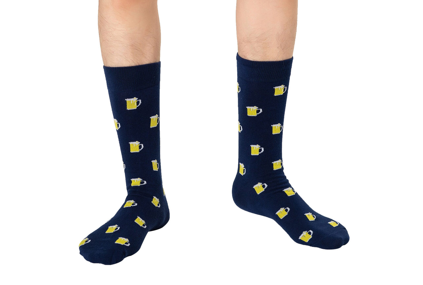 A person stands on a white background wearing Beer Socks in navy blue, featuring yellow beer mug patterns—perfect for beer lovers.