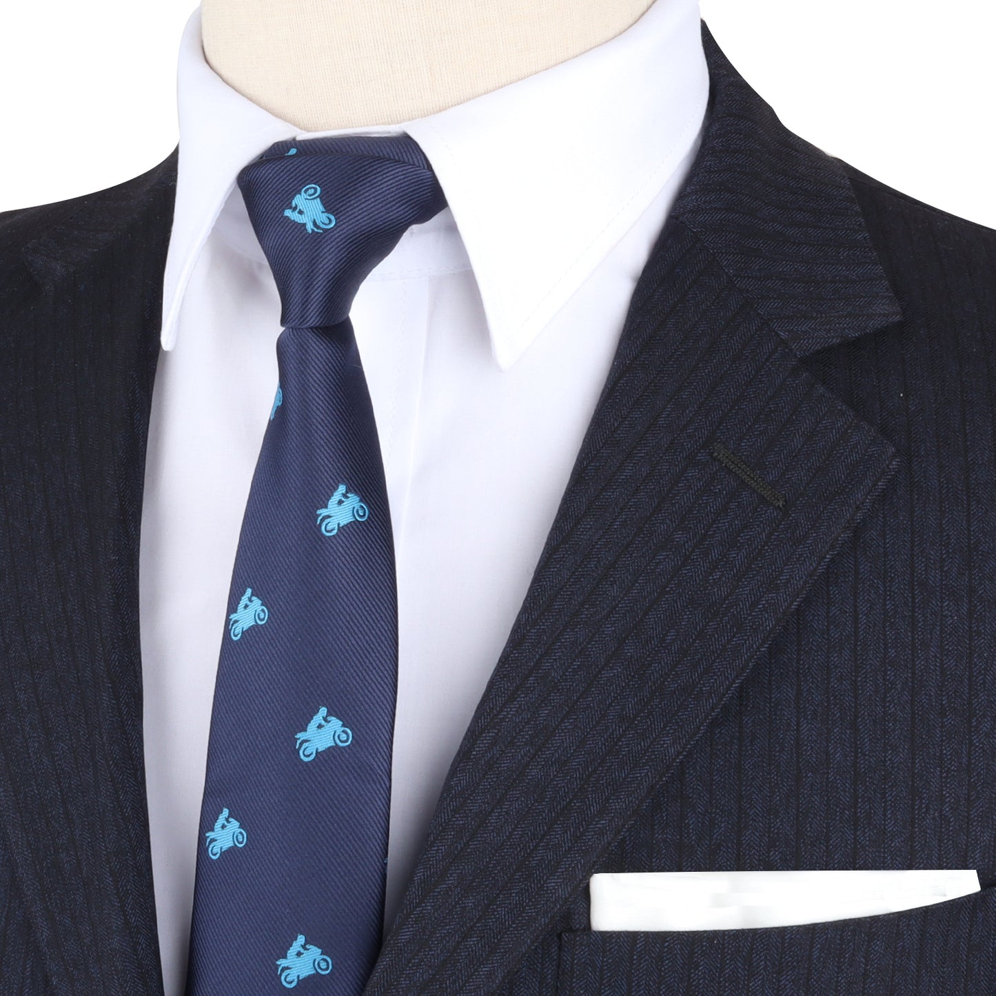 A close-up of a person wearing a pinstripe suit jacket, white dress shirt, and a Biker Skinny Tie. The suit's breast pocket has a white pocket square, adding an element of ride-inspired boldness to the ensemble.