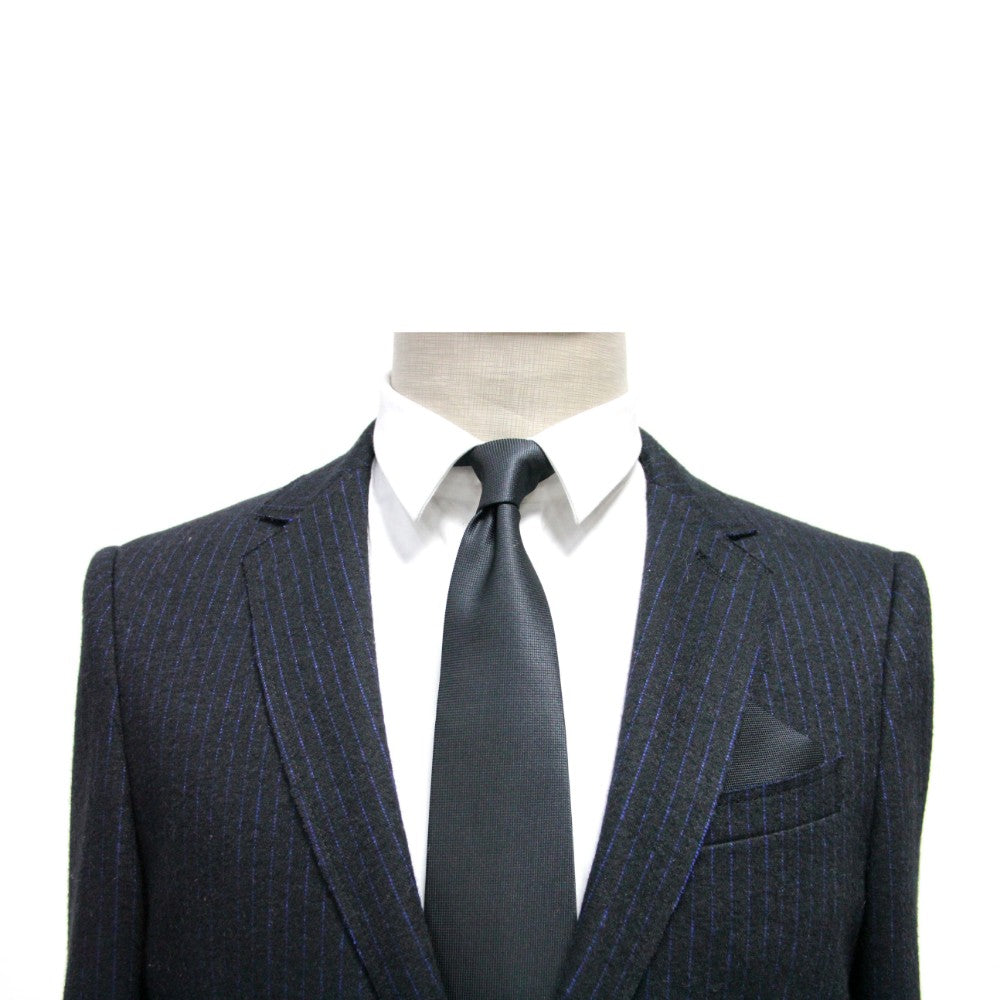 A formal mannequin in a suit and tie, accessorized with a Black Pocket Square.