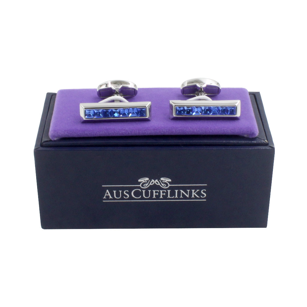 A pair of Blue Ice cufflinks in a purple box.