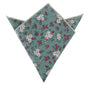 The Teal Floral Pocket Square, crafted from premium fabric, displays a triangular shape with green tones and white and red floral patterns. It is neatly folded with its pointed ends facing upward.