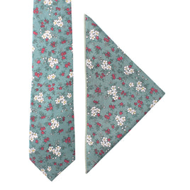 A blue, white, and pink floral patterned tie and matching pocket square set exudes a timeless style reminiscent of a delicate pastel bouquet.