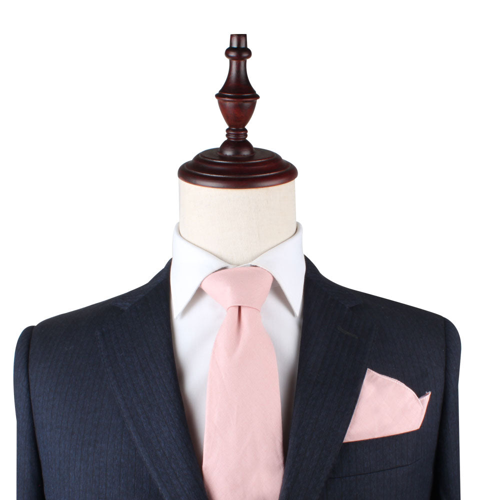 A mannequin wearing a Blush Pink Pocket Square and pink tie with standout style.