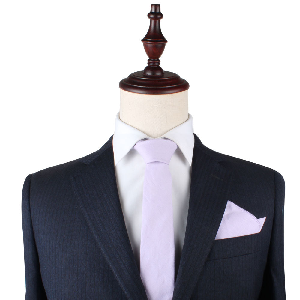 A luxurious black pinstripe suit graces the mannequin, elegantly paired with a crisp white shirt. The Blush Purple Skinny Necktie and Pocket Square Set adds a touch of sophistication, creating an impeccable ensemble.