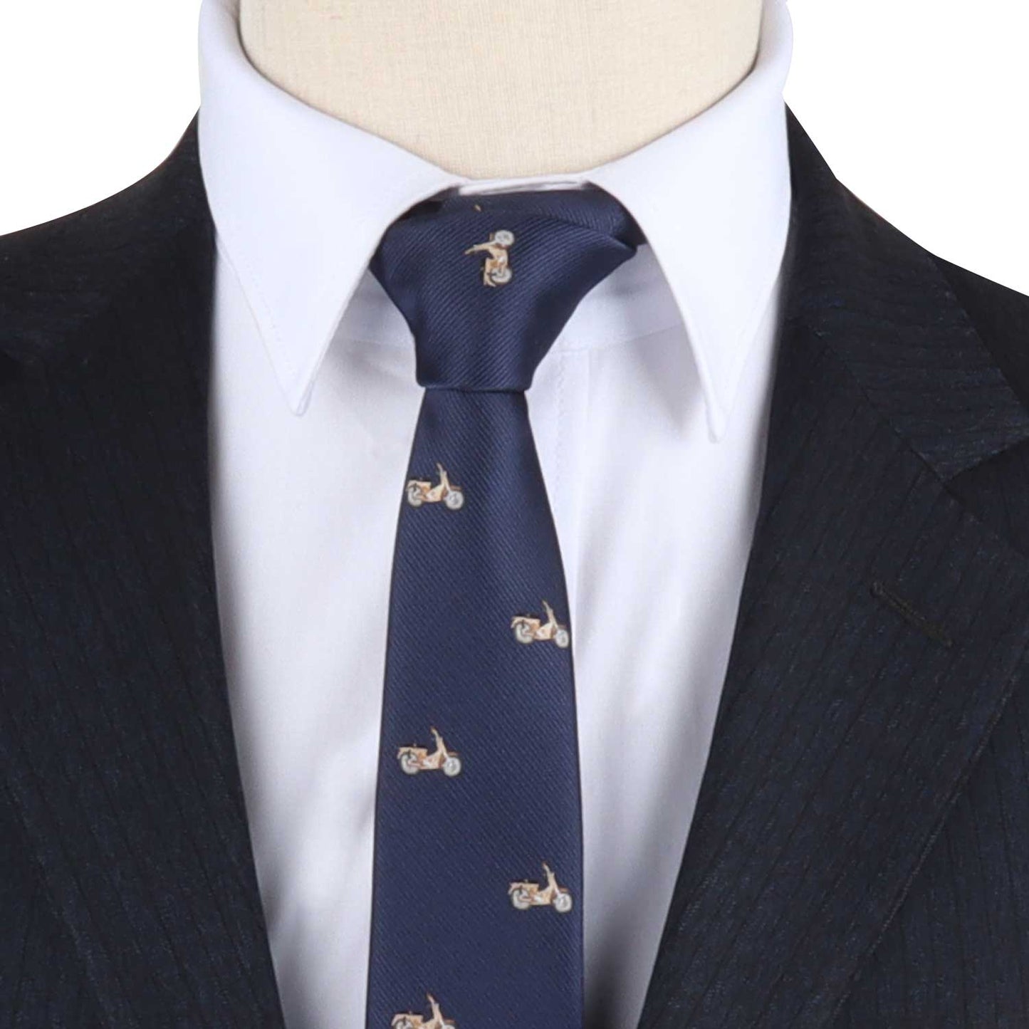 A close-up of a person exuding elegance in a dark pinstripe suit, a white shirt, and the Classic Motorbike Skinny Tie in navy.