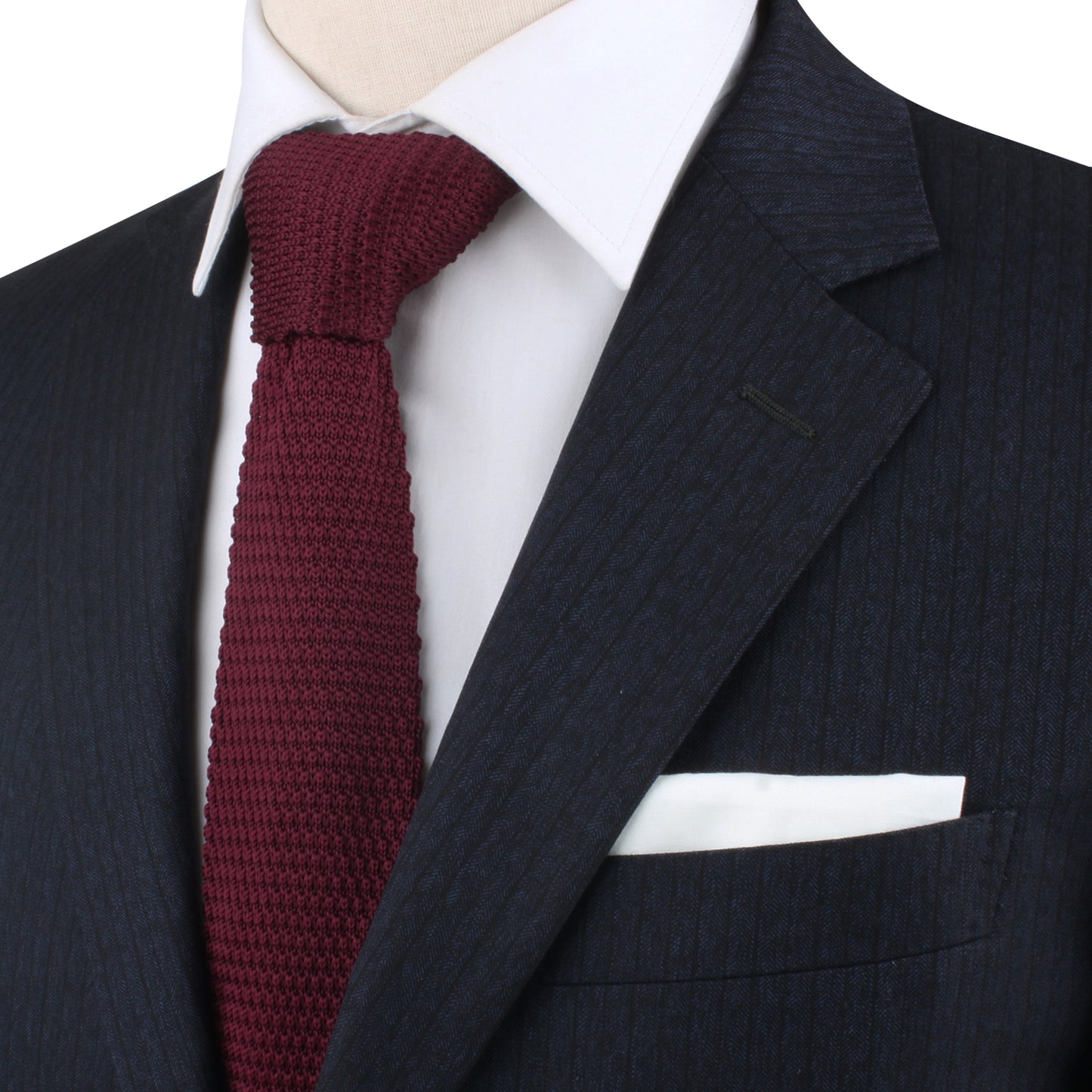 A close-up of a person wearing a dark pinstripe suit, white shirt, Maroon Knitted Skinny Tie, and white pocket square. The warm hues of the ensemble exude cozy elegance. Face is not visible.