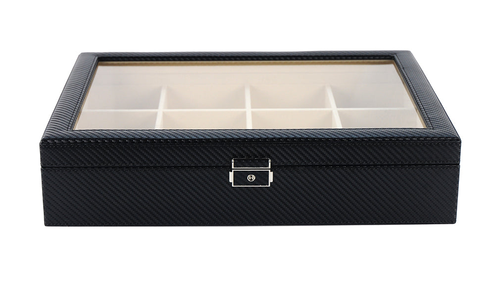 The Carbon Fibre Tie Box features a sleek black rectangular design with a glass lid, metal clasp, and multiple compartments—offering stylish, premium storage for both watches and ties in one elegant solution.