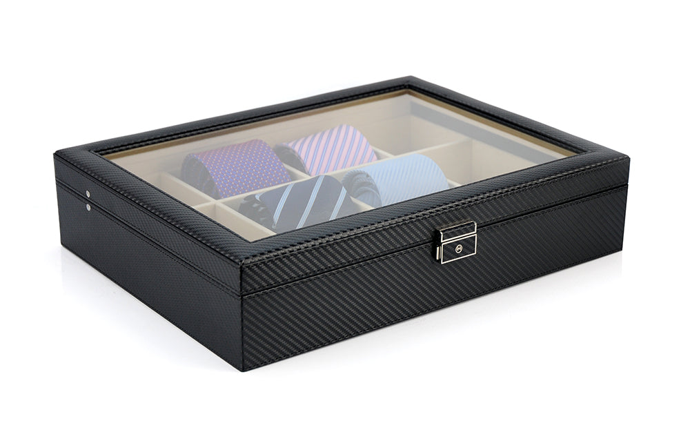 The Carbon Fibre Tie Box is a black textured premium case with a transparent lid, offering elegant tie storage with separate compartments for several rolled-up neckties.