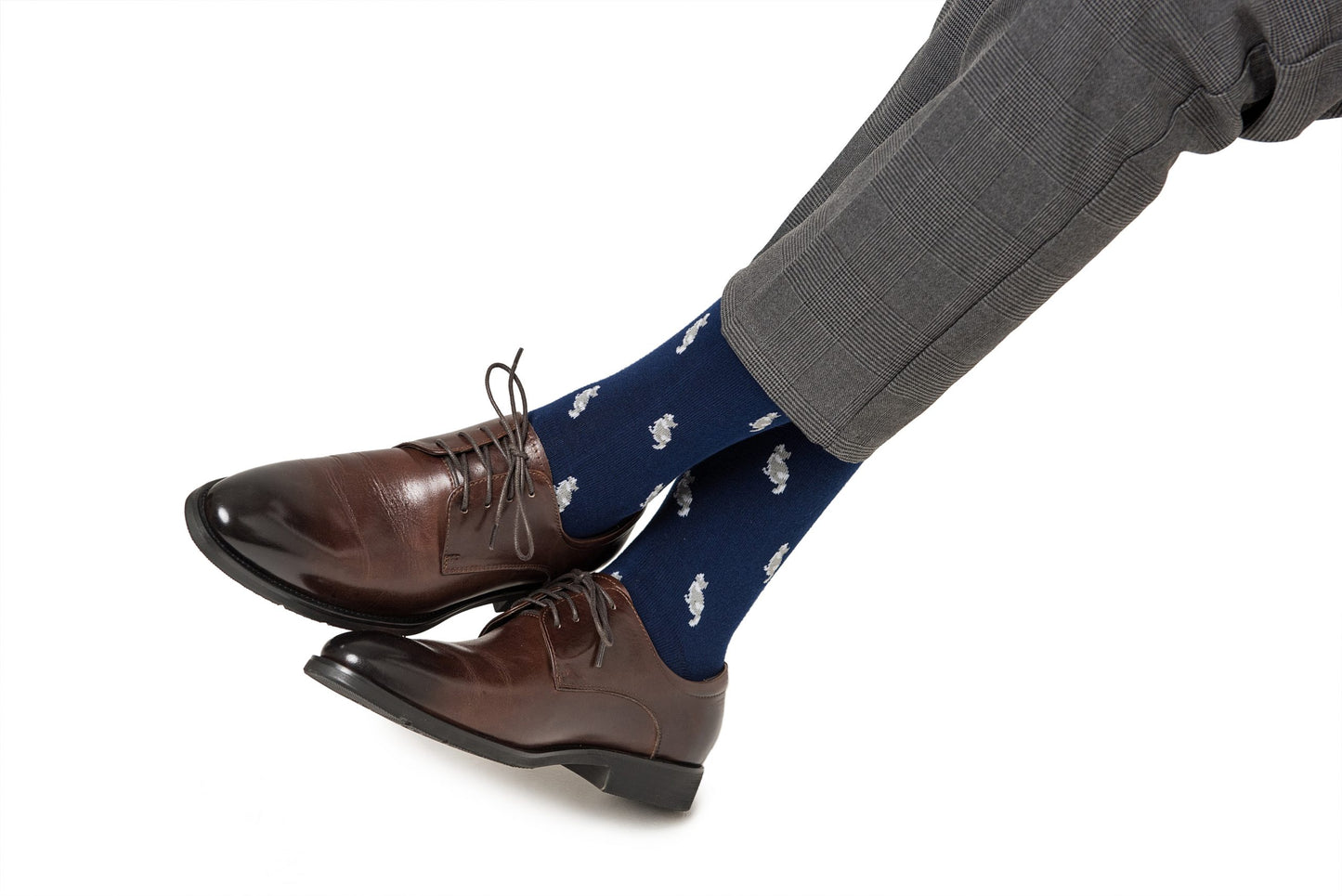 A pair of legs wearing brown shoes and Cat Socks.