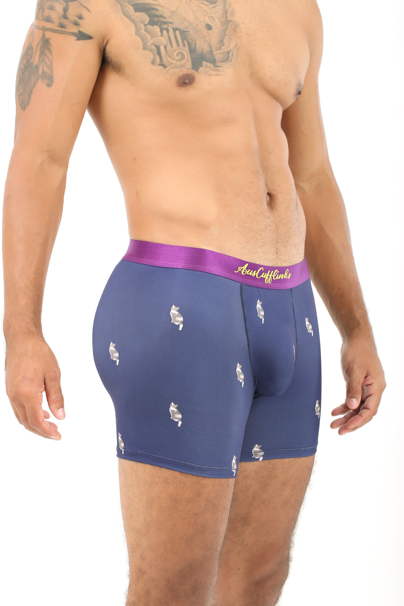 Modeling the Cat Underwear, a person stands with confidence against a white background, showcasing blue patterned boxer briefs featuring a purple waistband designed for a snug fit.