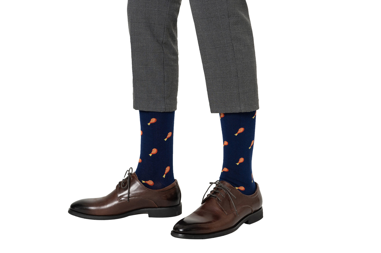 The person is sporting a layered style with gray checkered pants, strawberry cake socks featuring orange drumstick patterns, and brown dress shoes.