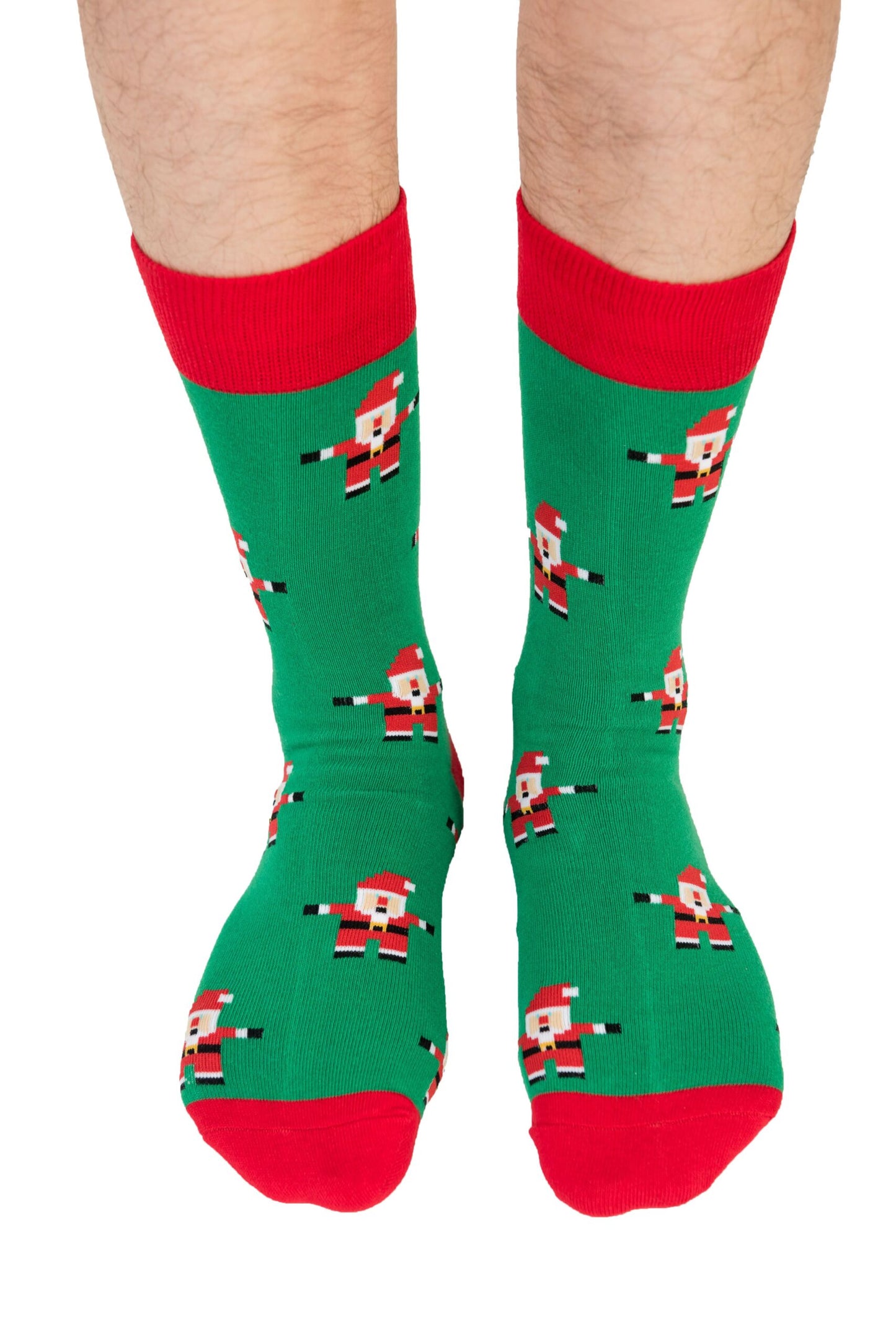 Person wearing Santa Socks featuring green fabric with red toes and cuffs, adorned with a pattern of Santa Clauses, showcasing some serious festive feet.