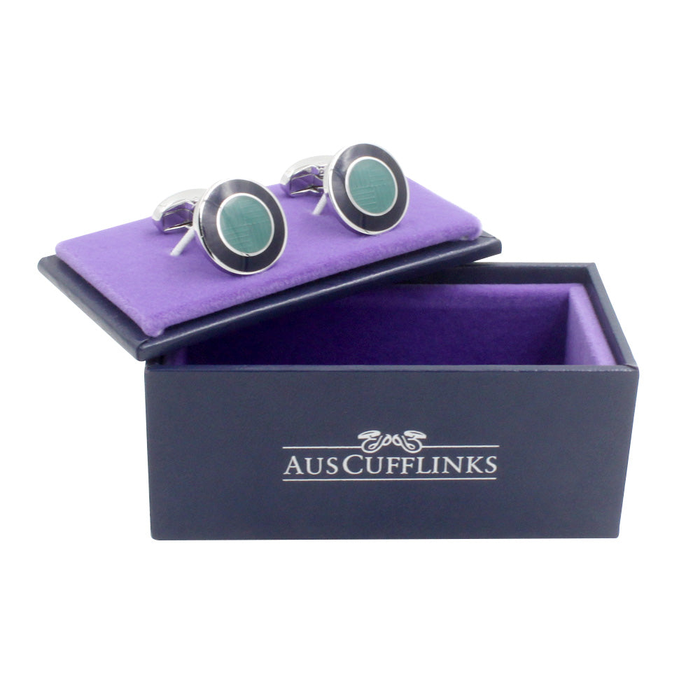 A pair of Circular Teal Cufflinks in a purple box with oceanic charm.